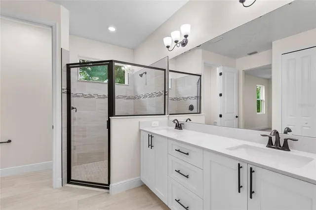 a bathroom with a double vanity sink mirror and shower