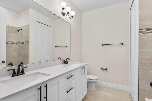 a bathroom with a sink a toilet and a mirror