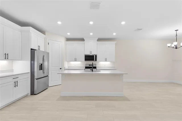 a view of kitchen with center island stainless steel appliances and cabinets