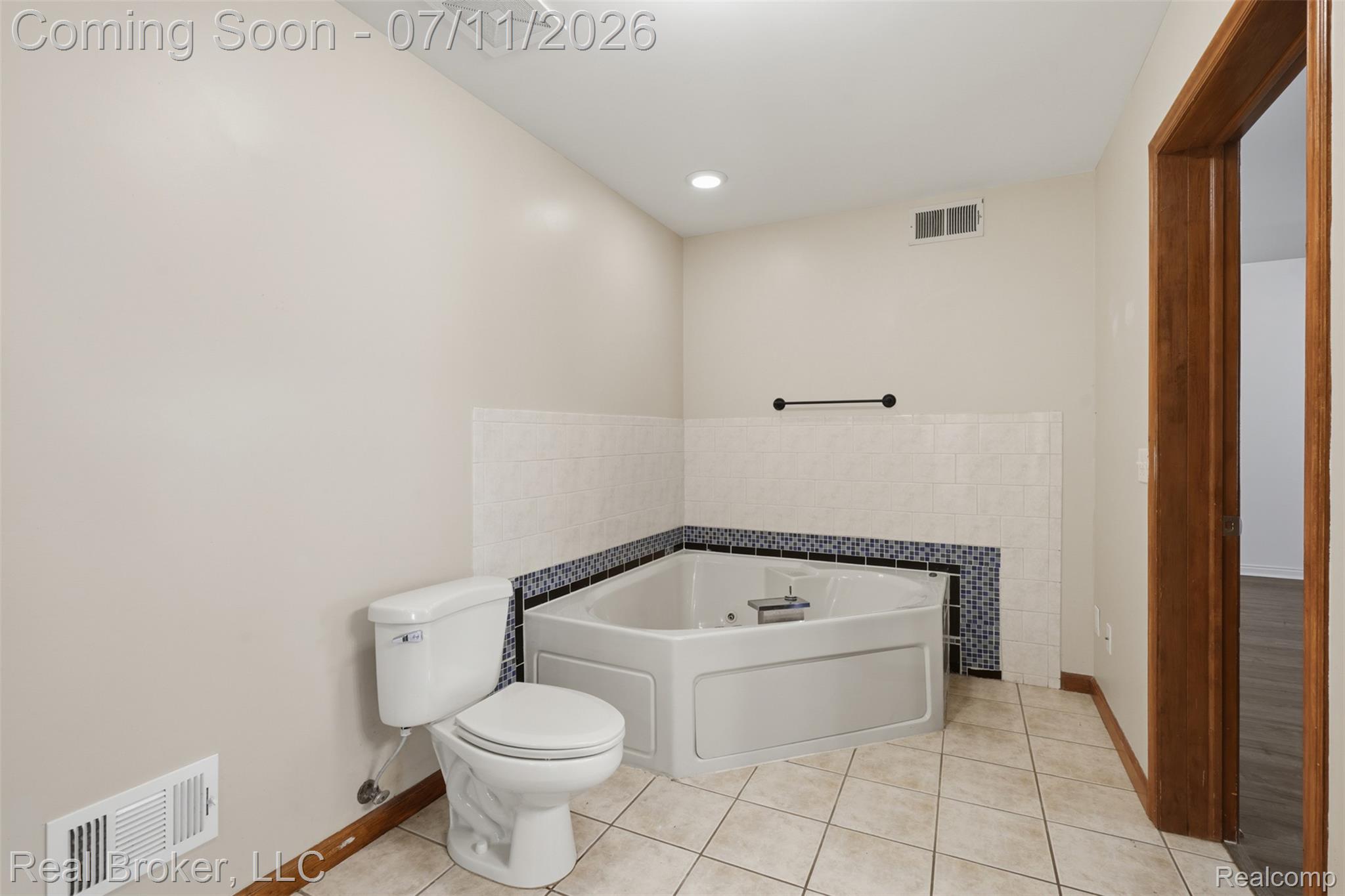1050 West Brocker Road Metamora, MI 48455 - Photo 34 of 55 Corner soaking tub with tiled surround featuring a decorative mosaic accent