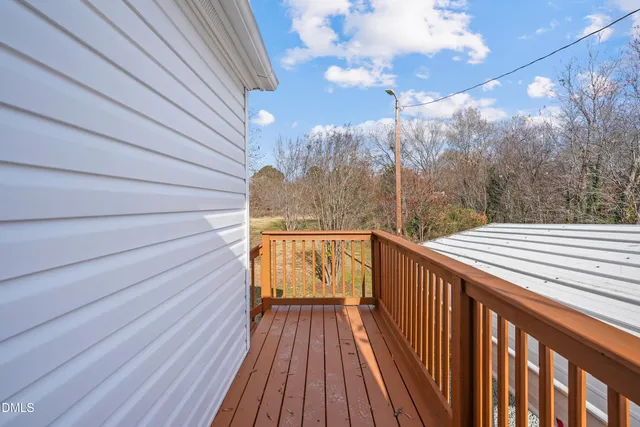a view of balcony with wooden floor and fence