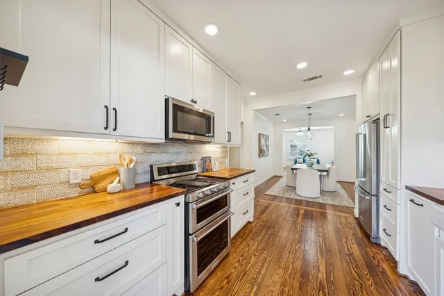 a kitchen with granite countertop a sink stove refrigerator and cabinets