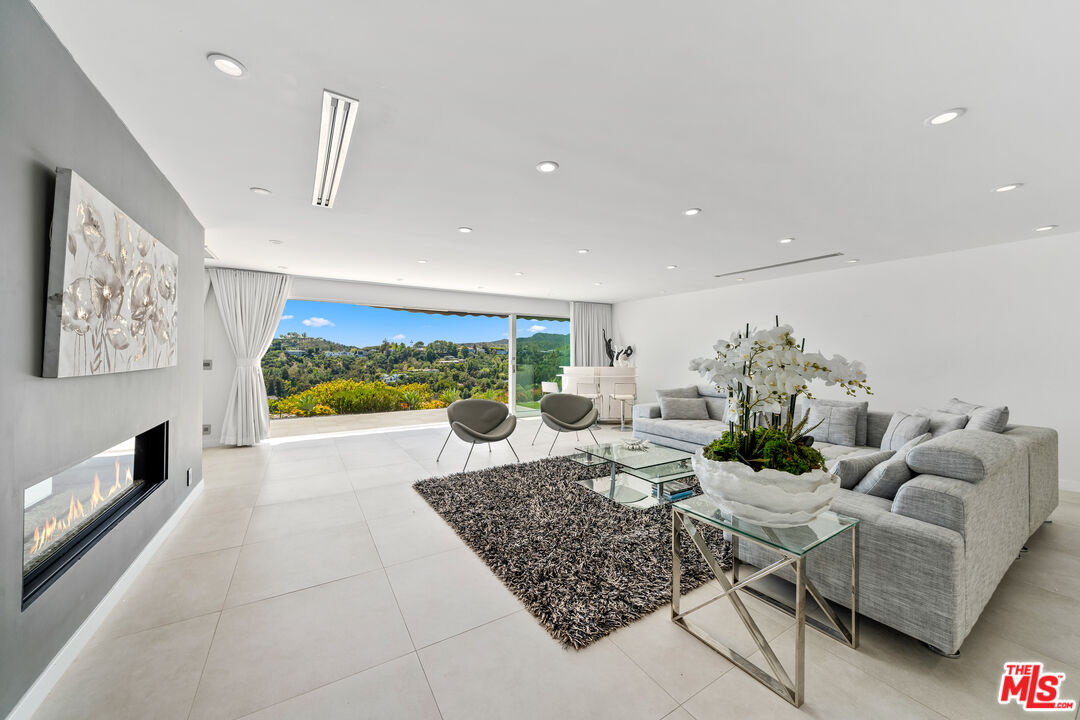 849 Glenmere Way Los Angeles, CA 90049 - Photo 12 of 51 a living room with furniture floor to ceiling window and a flat screen tv