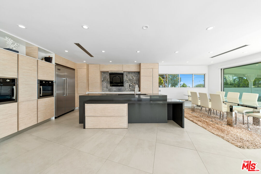 849 Glenmere Way Los Angeles, CA 90049 - Photo 18 of 51 a large kitchen with stainless steel appliances kitchen island granite countertop a large counter top and stainless steel appliances