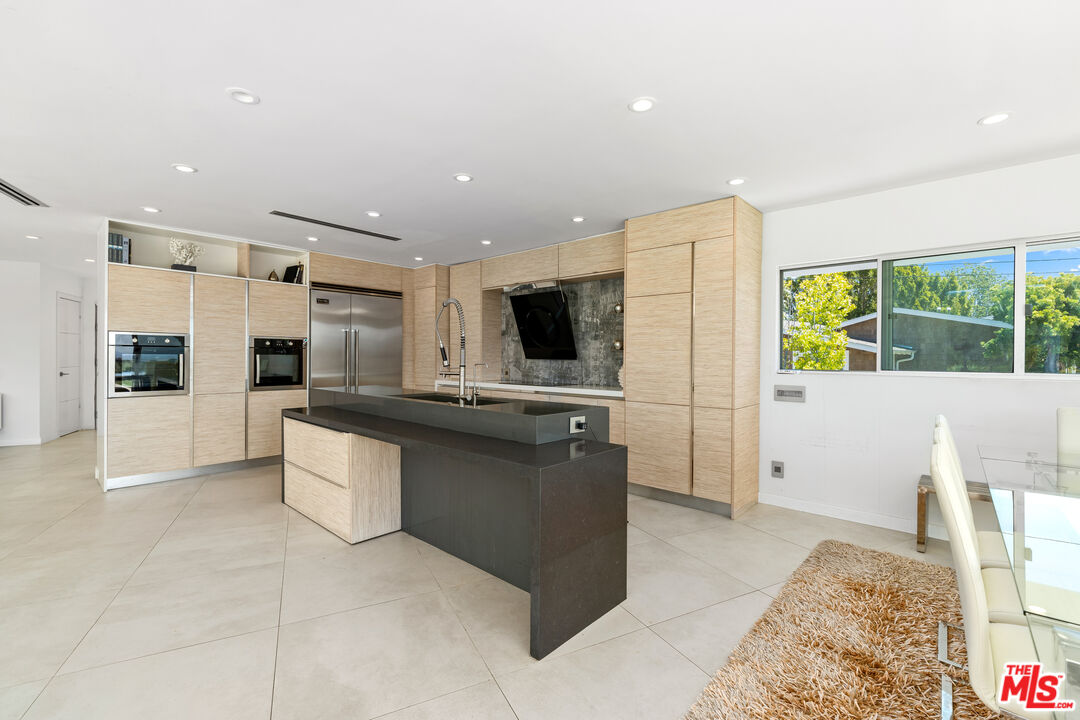 849 Glenmere Way Los Angeles, CA 90049 - Photo 19 of 51 a view of kitchen with stainless steel appliances kitchen island granite countertop a refrigerator and a stove top oven