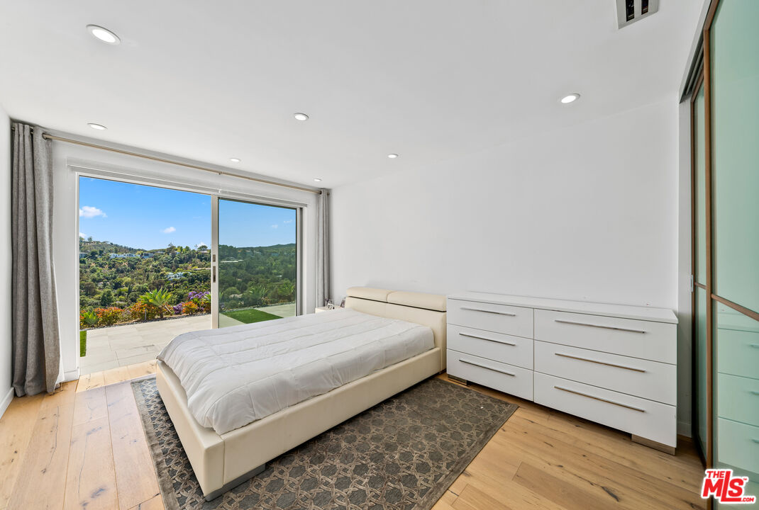 849 Glenmere Way Los Angeles, CA 90049 - Photo 29 of 51 a bedroom with a large bed and a large window
