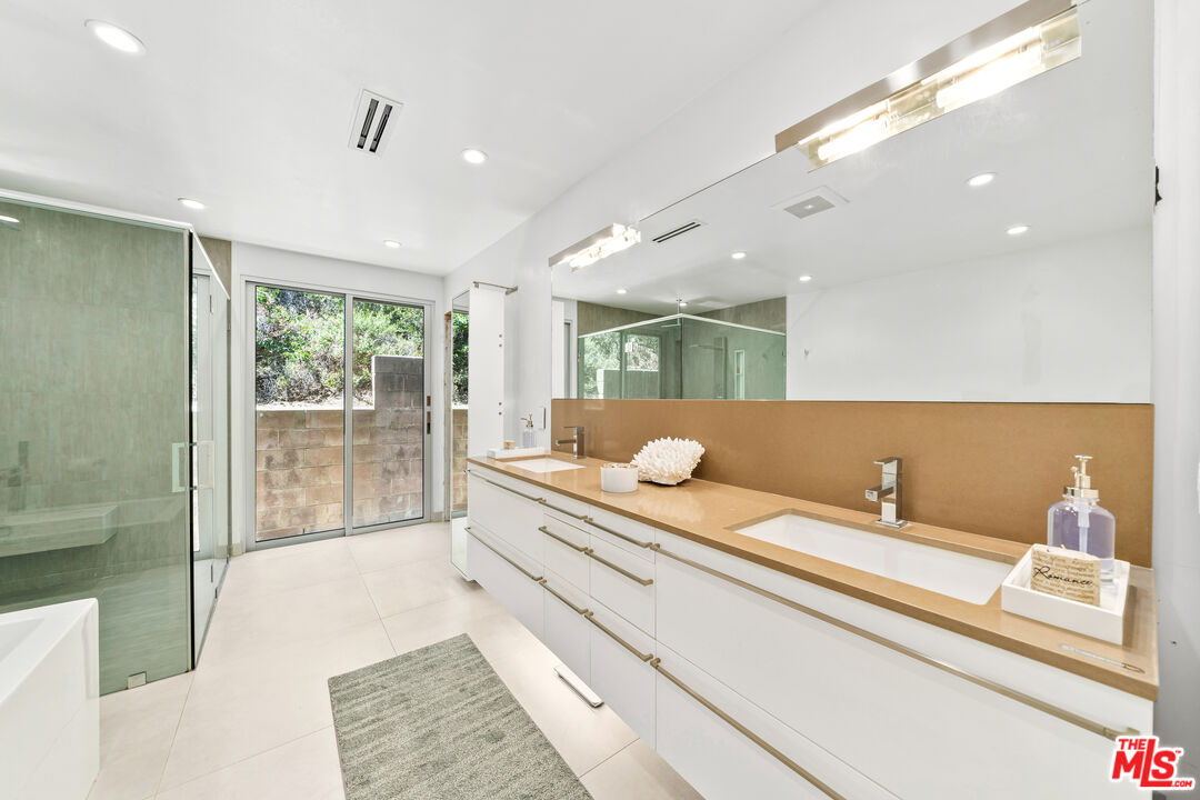 849 Glenmere Way Los Angeles, CA 90049 - Photo 38 of 51 a bathroom with a double vanity sink and mirror