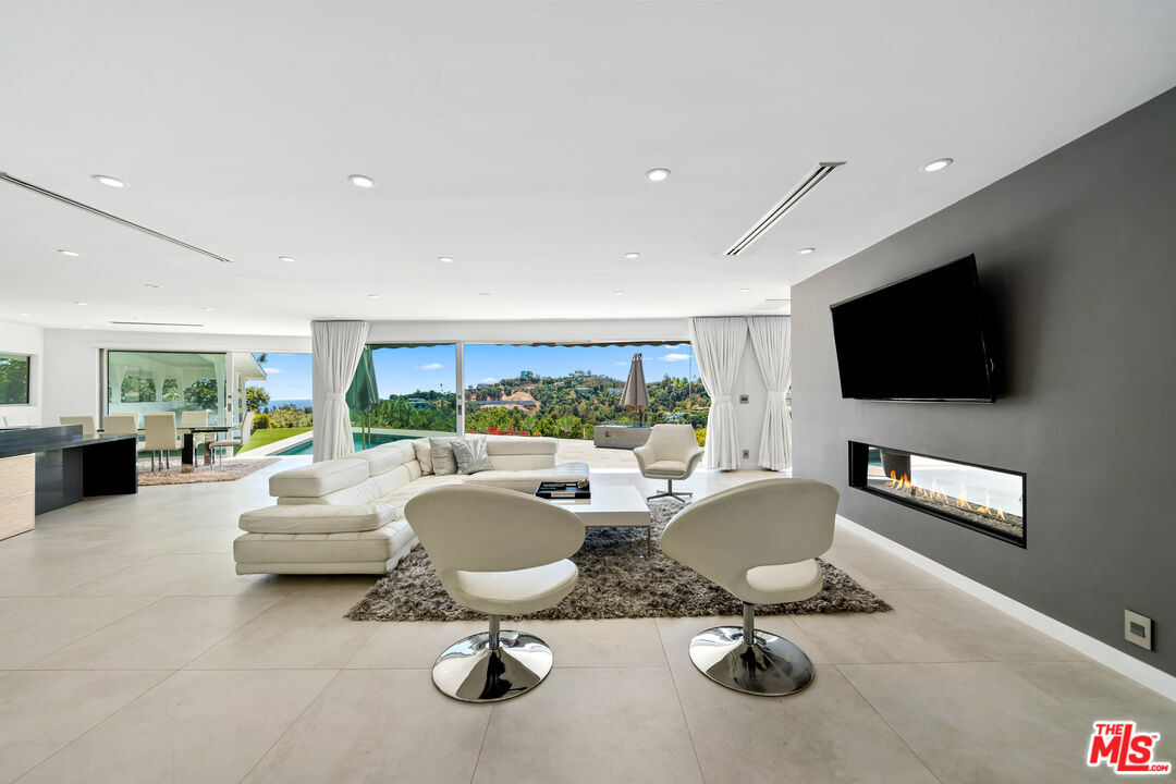 849 Glenmere Way Los Angeles, CA 90049 - Photo 10 of 51 a living room with furniture a flat screen tv and a large window