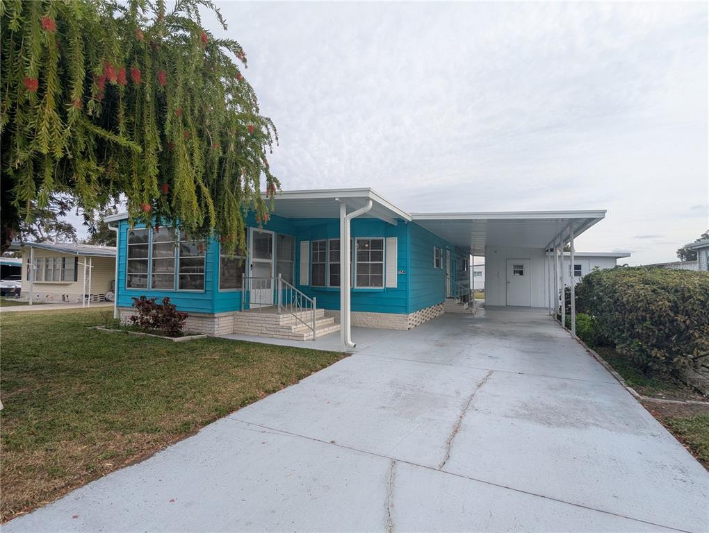 a view of a house with a yard and potted plants