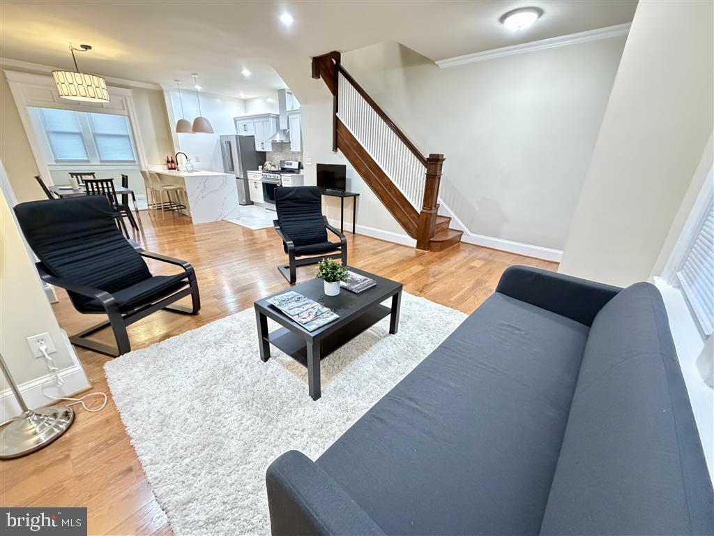 1154 4th Street Northeast Washington, DC 20002 - Photo 3 of 24 a living room with couches and kitchen view with wooden floor