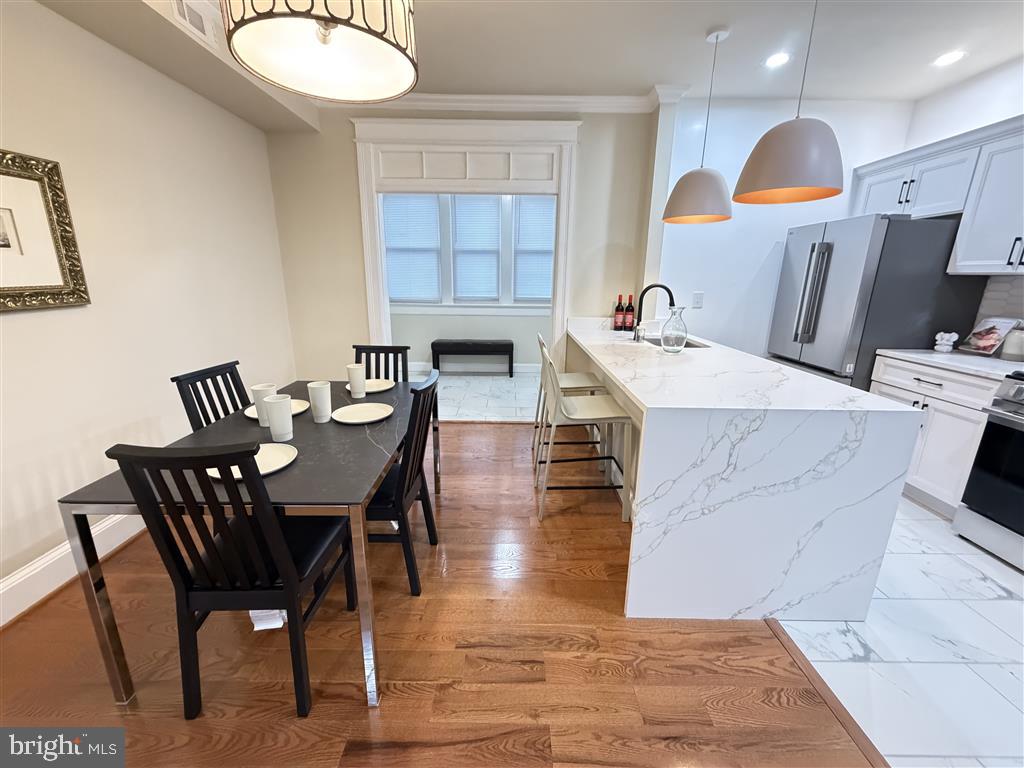 1154 4th Street Northeast Washington, DC 20002 - Photo 6 of 24 a kitchen with stainless steel appliances kitchen island granite countertop a table chairs and a sink