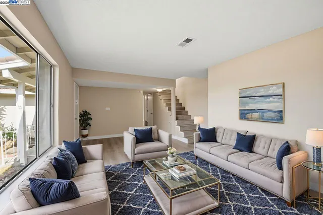 a living room with furniture a rug and a large window