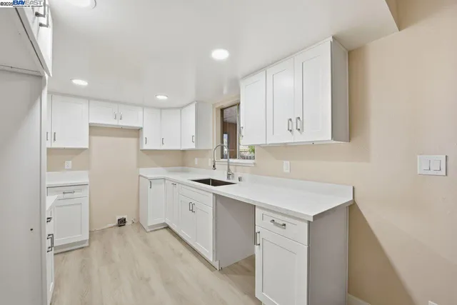 a kitchen with white cabinets and white appliances