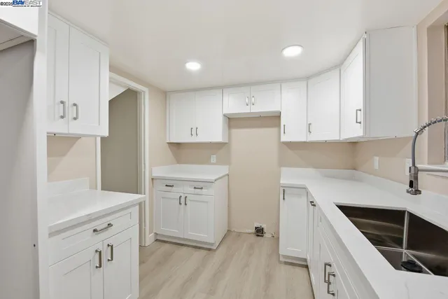 a kitchen with white cabinets and white appliances