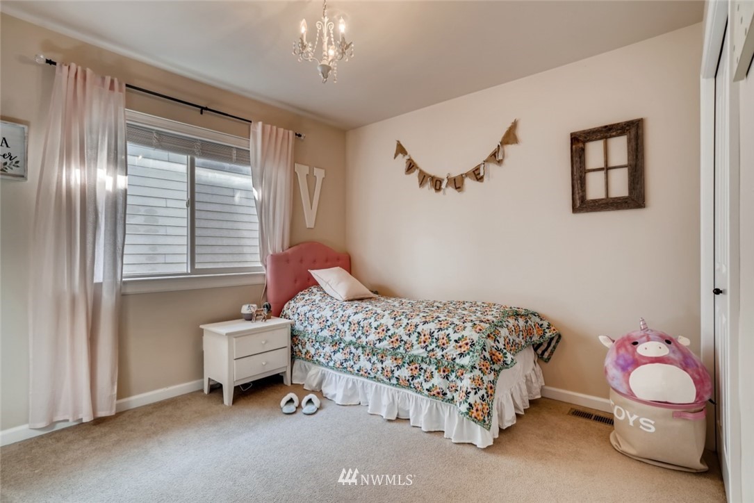 4121 223rd Place Southeast Bothell, WA 98021 - Photo 13 of 15 a bedroom with a bed and a chandelier