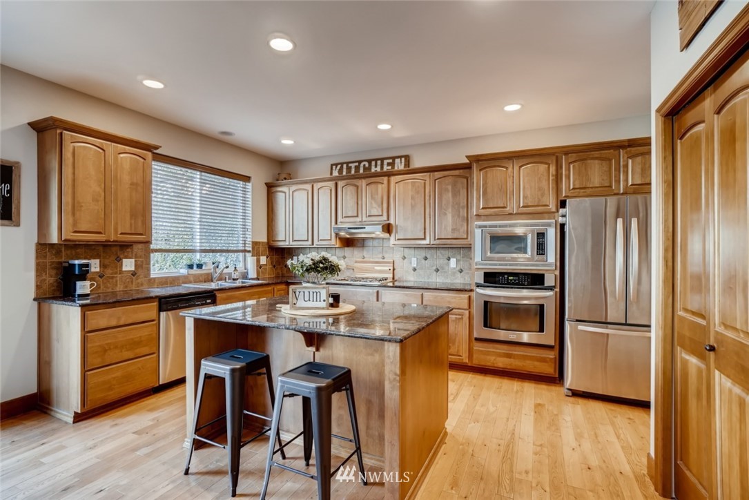4121 223rd Place Southeast Bothell, WA 98021 - Photo 6 of 15 a kitchen with refrigerator cabinets and wooden floor