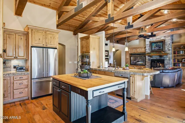 a kitchen with stainless steel appliances granite countertop a stove a refrigerator and a dining table