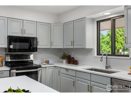 a kitchen with a sink a stove a refrigerator a dining table and chairs