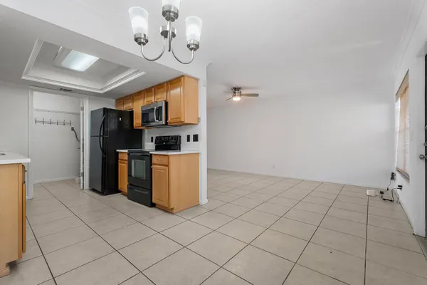 a kitchen with stainless steel appliances granite countertop a refrigerator a stove top oven and a sink