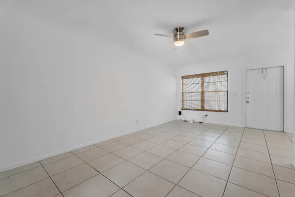 an empty room with windows and ceiling fan
