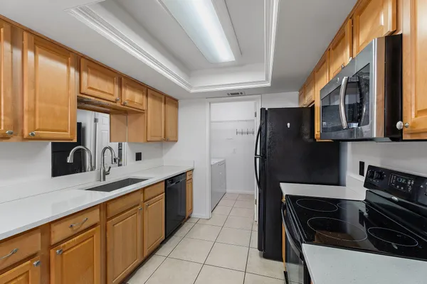 a kitchen with stainless steel appliances granite countertop a refrigerator and a sink