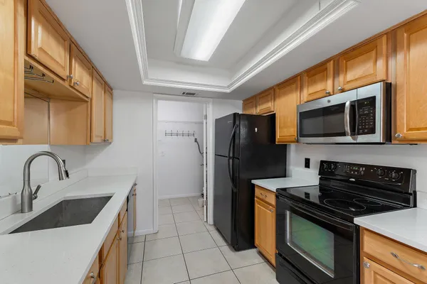 a kitchen with stainless steel appliances granite countertop a stove microwave refrigerator and sink