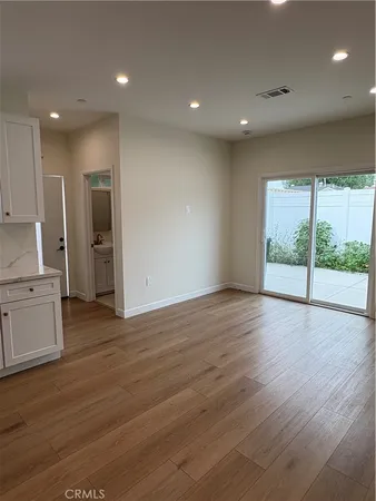 an empty room with wooden floor and outdoor view