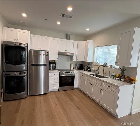 a kitchen with a refrigerator a stove top oven a sink and cabinets