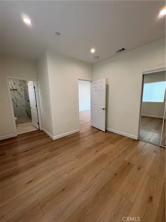a view of empty room with wooden floor