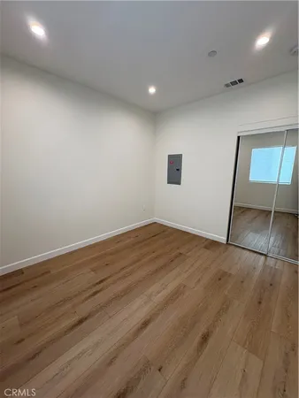 an empty room with wooden floor and entrance