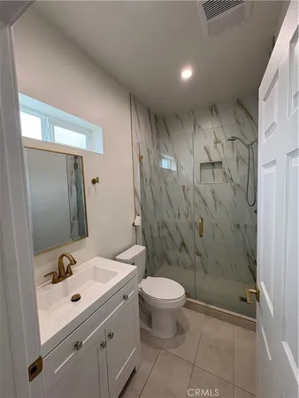 a bathroom with a sink mirror vanity and toilet