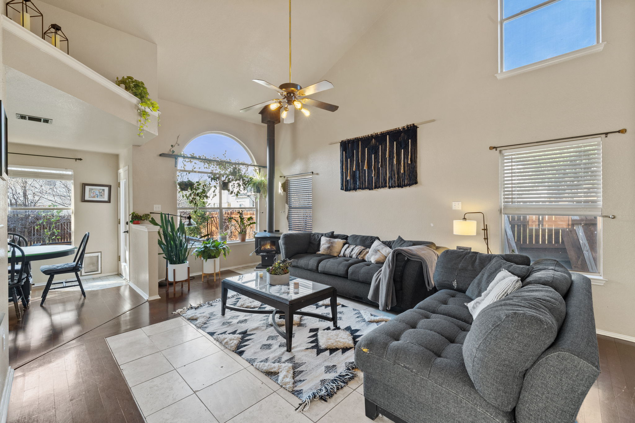 Living room featuring dark wood finished floors, ceiling fan, lofted ceiling, and plenty of natural light