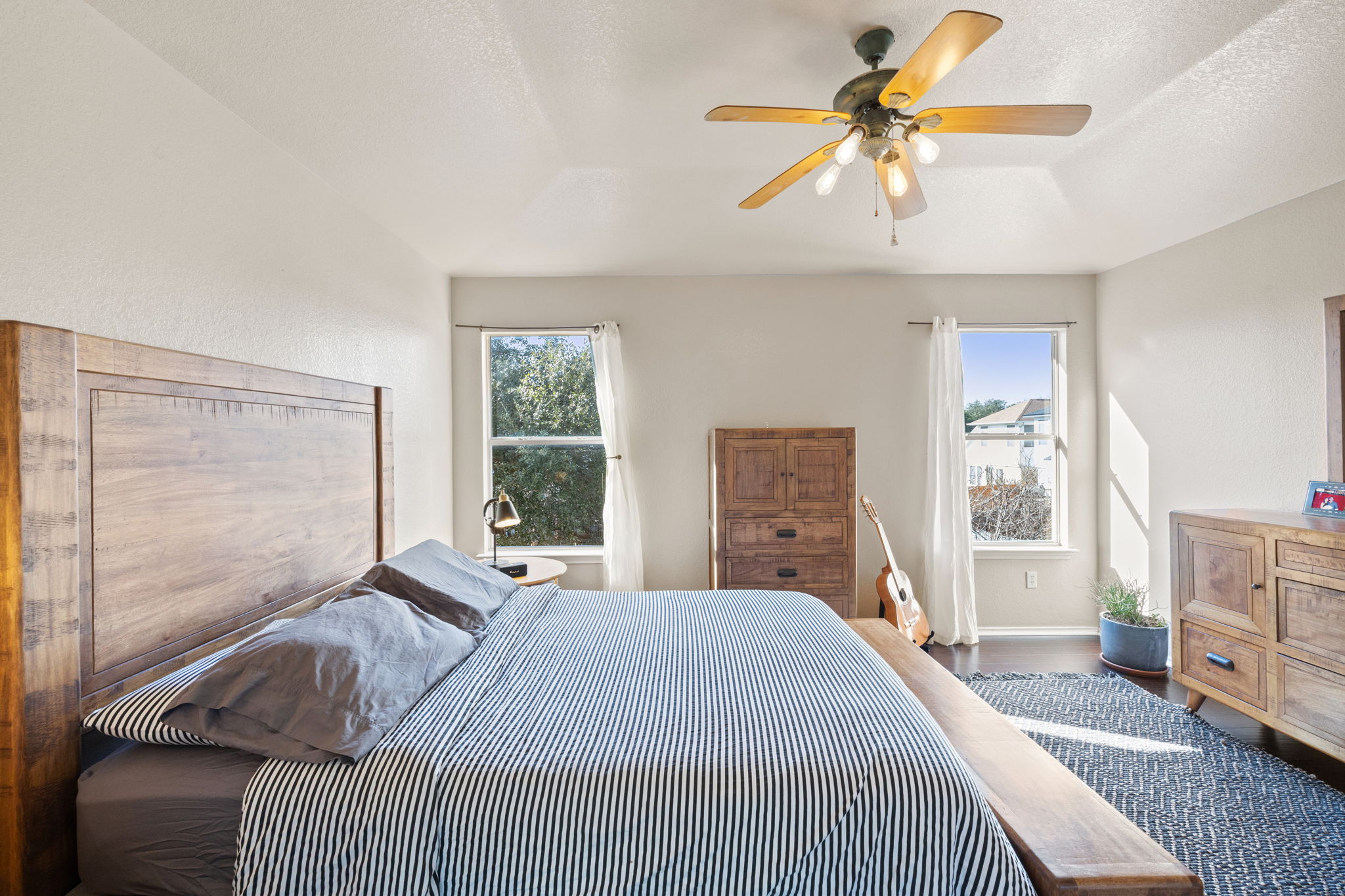 17536 Bishopsgate Drive Pflugerville, TX 78660 - Photo 17 of 28 Bedroom with a textured ceiling, dark wood-style flooring, multiple windows, and a ceiling fan