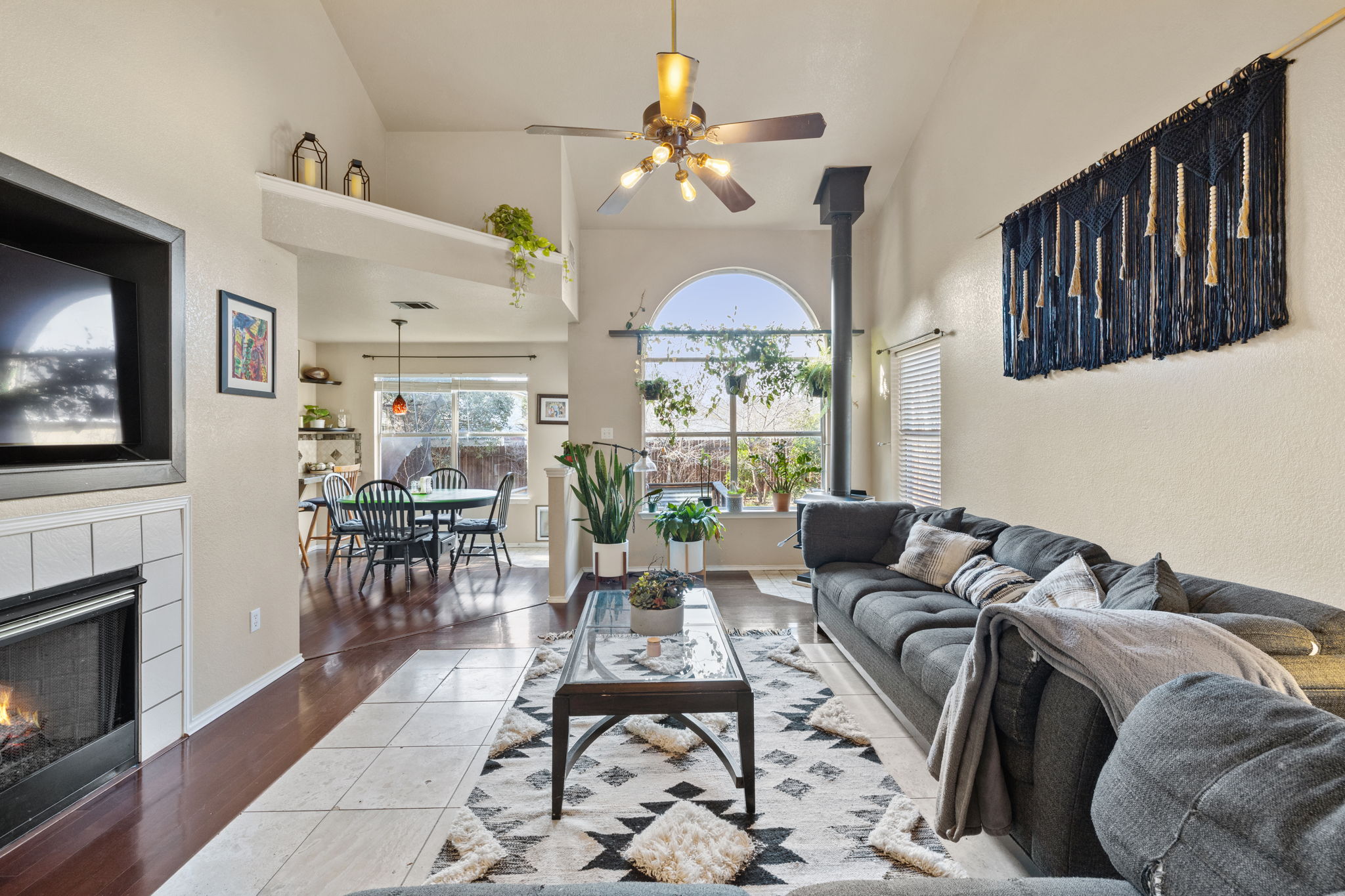 17536 Bishopsgate Drive Pflugerville, TX 78660 - Photo 4 of 28 Living room featuring ceiling fan, wood finished floors, lofted ceiling, and a tiled fireplace