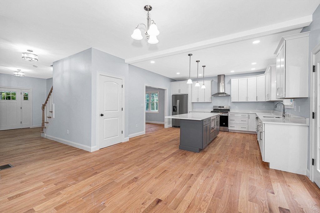 15 Norris Road Tyngsborough, MA 01879 - Photo 11 of 42 a large kitchen with cabinets wooden floor and stainless steel appliances