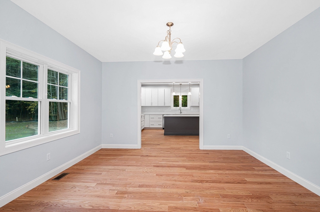 15 Norris Road Tyngsborough, MA 01879 - Photo 15 of 42 a view of an empty room with a window and wooden floor