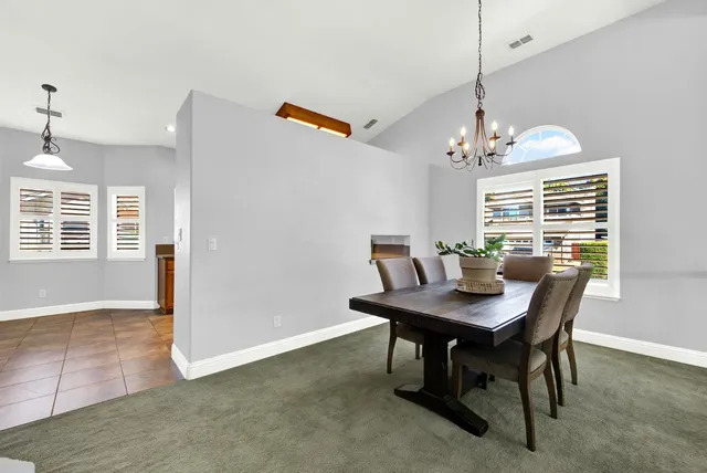 a dining room with furniture potted plants and wooden floor
