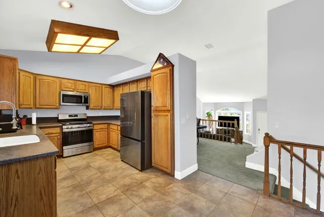 an empty room with windows fireplace and wooden floor