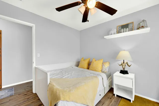 a view of a backyard with table and chairs potted plants and large tree