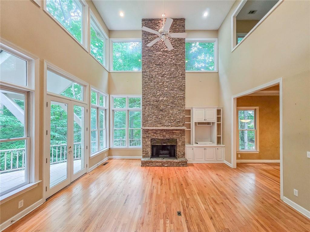 3712 Frederica Road Northwest Berkeley Lake, GA 30096 - Photo 19 of 49 a view of an empty room with wooden floor fireplace and a window