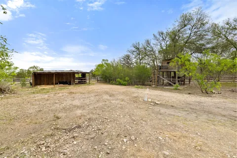 a view of a yard with wooden fence