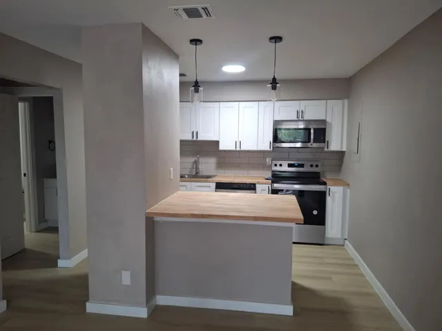 a kitchen with stainless steel appliances a stove microwave and a refrigerator