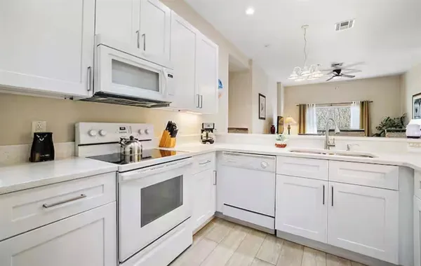 a kitchen with white cabinets stainless steel appliances and sink