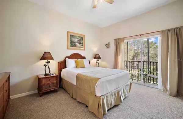 a bedroom with a balcony a bed and a large window