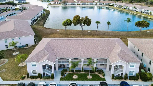 an aerial view of residential houses with outdoor space and lake view