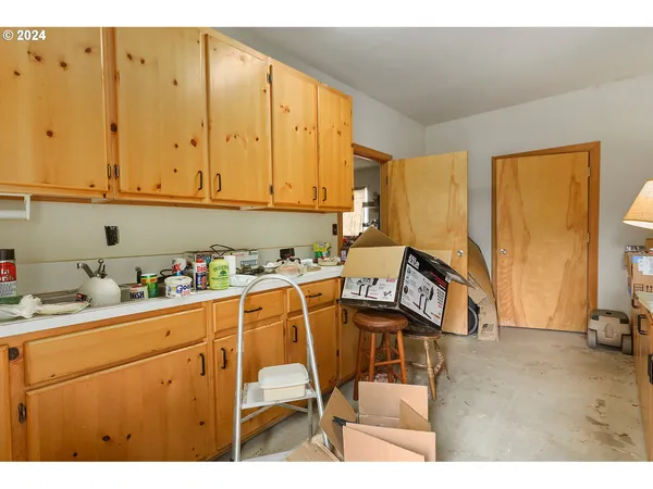 a kitchen with a chair and white appliances