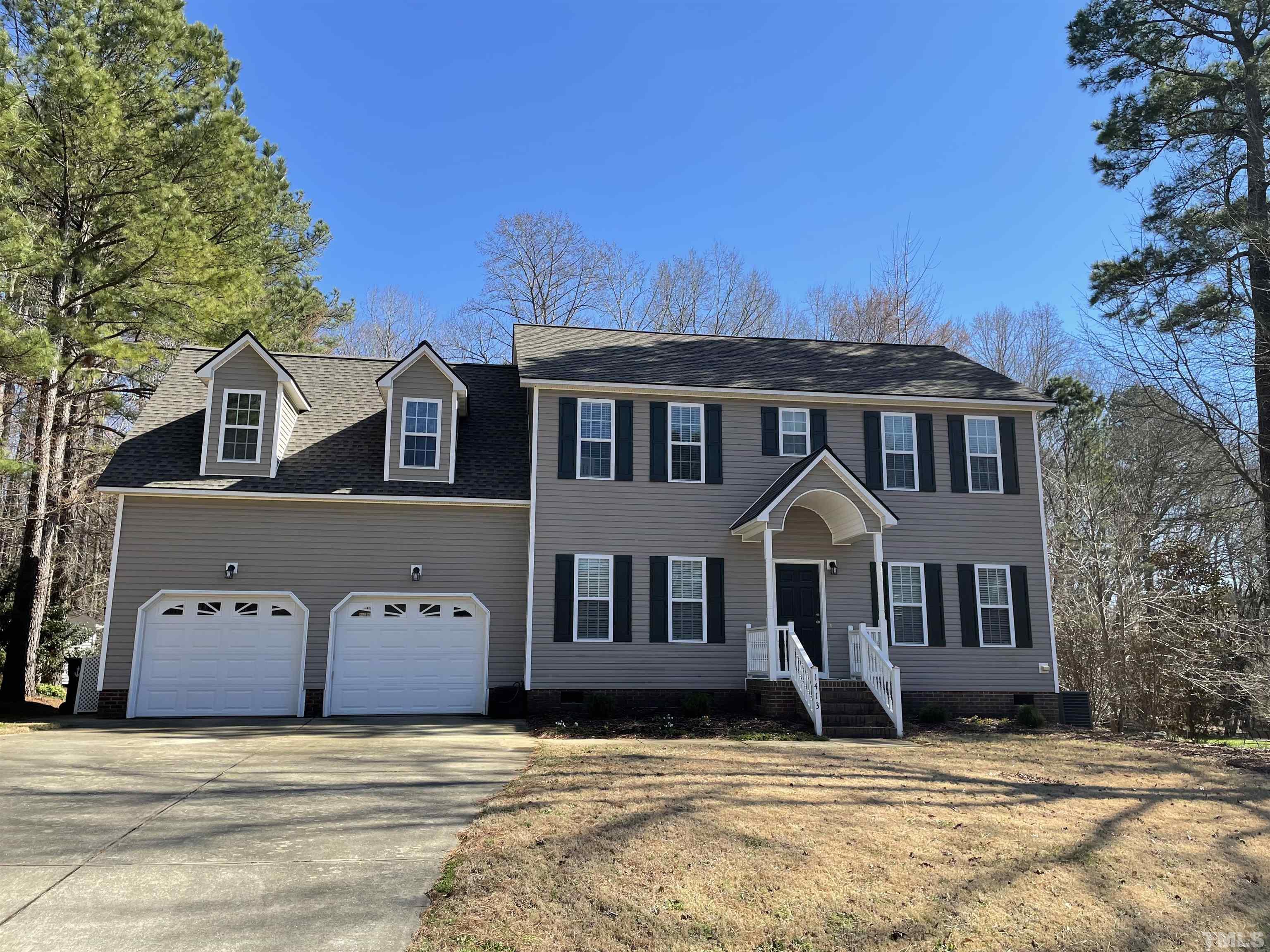 a view of a house with a big yard and large trees