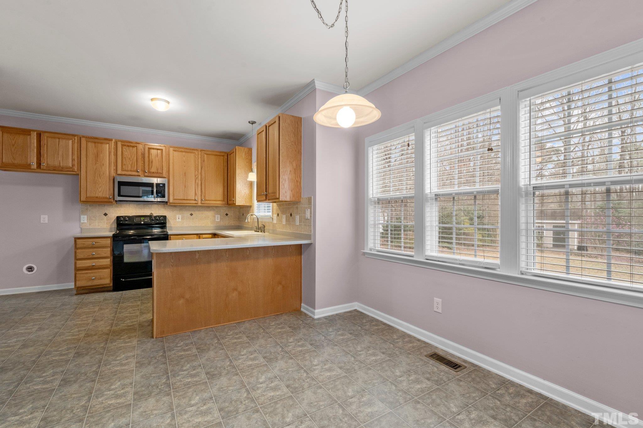 1413 Shady Rise Glen Raleigh, NC 27603 - Photo 21 of 39 a kitchen with stainless steel appliances granite countertop a stove a sink a refrigerator and a window