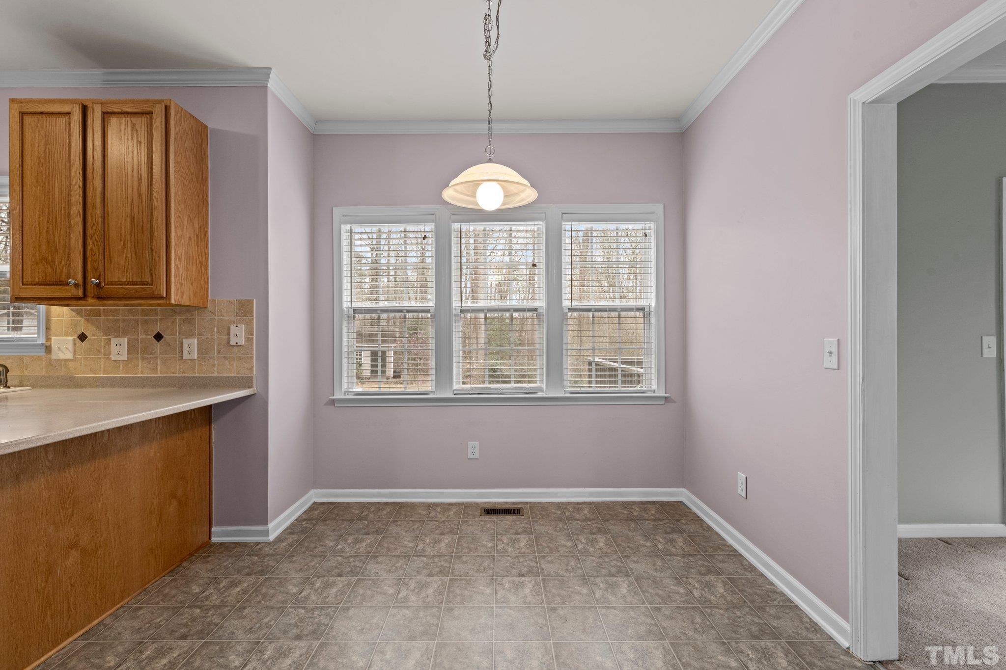 1413 Shady Rise Glen Raleigh, NC 27603 - Photo 22 of 39 a view of an empty room with chandelier fan and windows