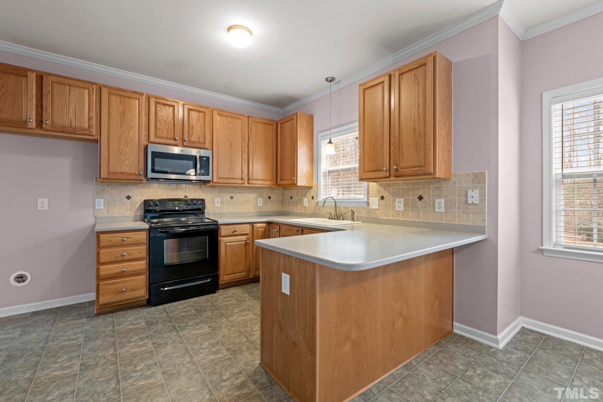 1413 Shady Rise Glen Raleigh, NC 27603 - Photo 23 of 39 a kitchen with kitchen island granite countertop a stove top oven sink and cabinets